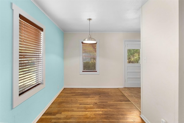 interior space featuring crown molding, wood-type flooring, and plenty of natural light