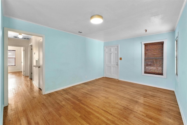 unfurnished room with crown molding and light hardwood / wood-style flooring