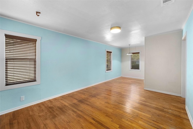 empty room with wood-type flooring and ornamental molding