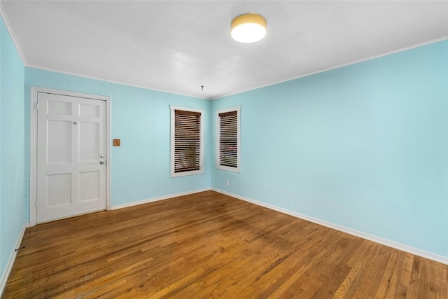 empty room featuring hardwood / wood-style floors and crown molding