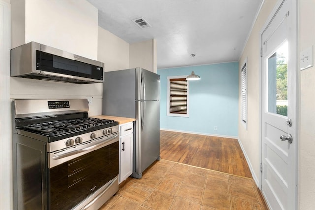 kitchen with light hardwood / wood-style flooring, stainless steel appliances, and pendant lighting