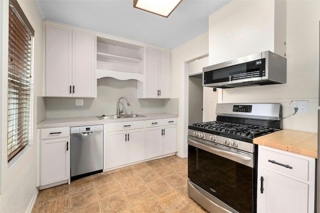 4804 Tanney St, Austin, TX 78721 - kitchen featuring stainless steel appliances, a sink, open shelves, and white cabinetry
