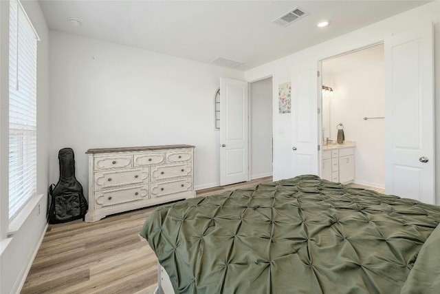 bedroom featuring light hardwood / wood-style floors and ensuite bathroom