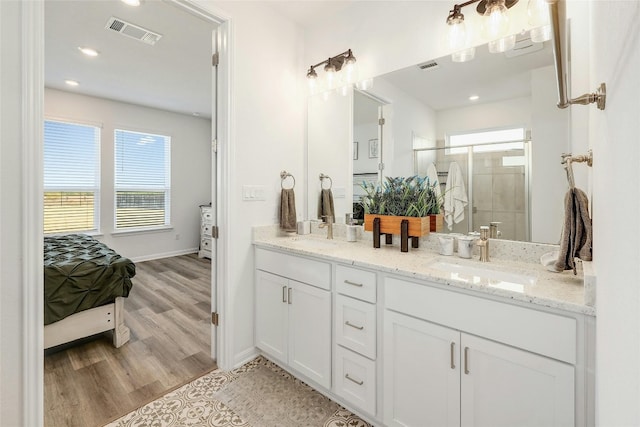 bathroom featuring a shower with door, vanity, and hardwood / wood-style floors