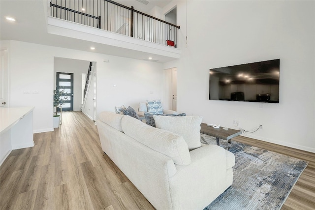 living room with a high ceiling and light hardwood / wood-style flooring