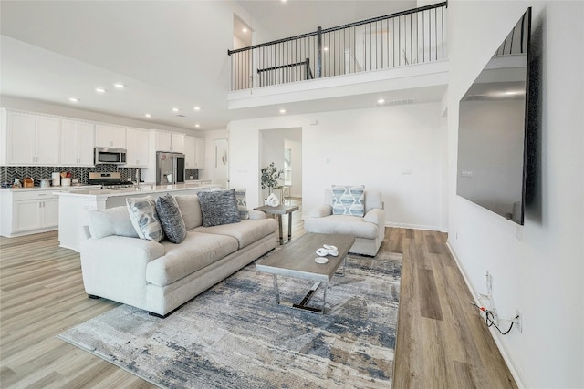 living room with a high ceiling and light wood-type flooring