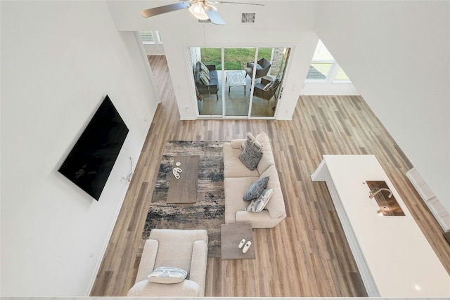 living room featuring wood-type flooring and ceiling fan