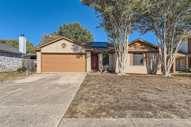 ranch-style home with solar panels and a garage