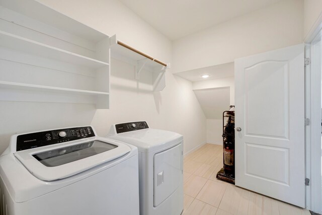 laundry room with washing machine and clothes dryer and light tile patterned floors