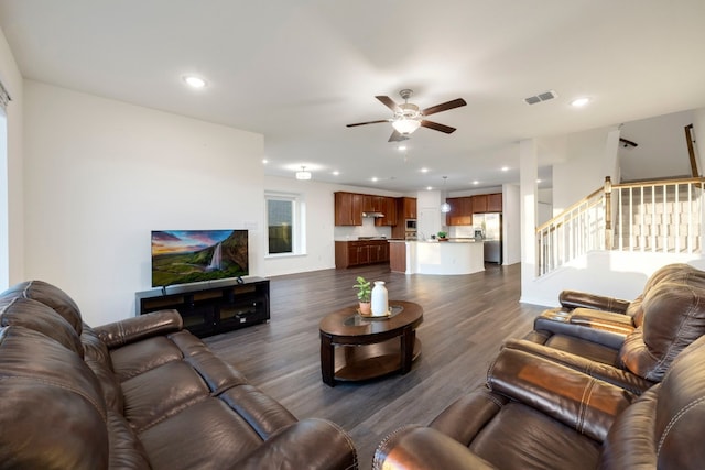 living room with dark wood-type flooring and ceiling fan