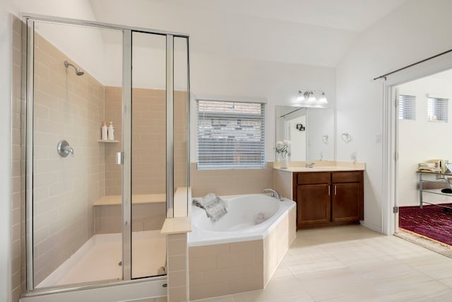 bathroom featuring a wealth of natural light, independent shower and bath, vanity, and vaulted ceiling