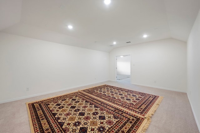 spare room with vaulted ceiling and light colored carpet