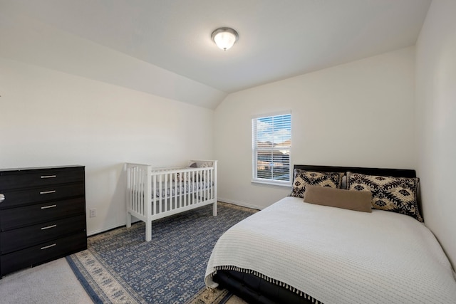 bedroom featuring vaulted ceiling and dark colored carpet