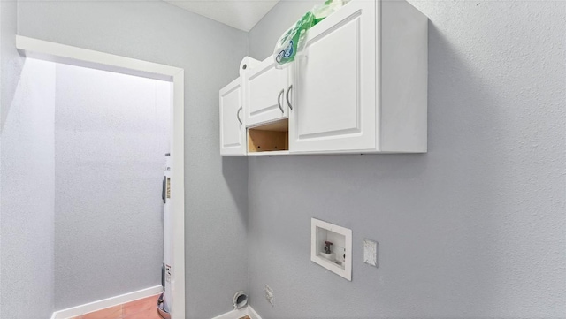 washroom featuring hookup for a washing machine, cabinet space, and baseboards