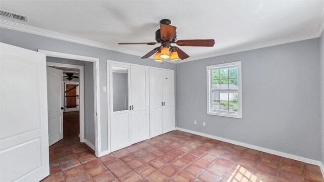 unfurnished bedroom featuring ornamental molding, a closet, baseboards, and ceiling fan