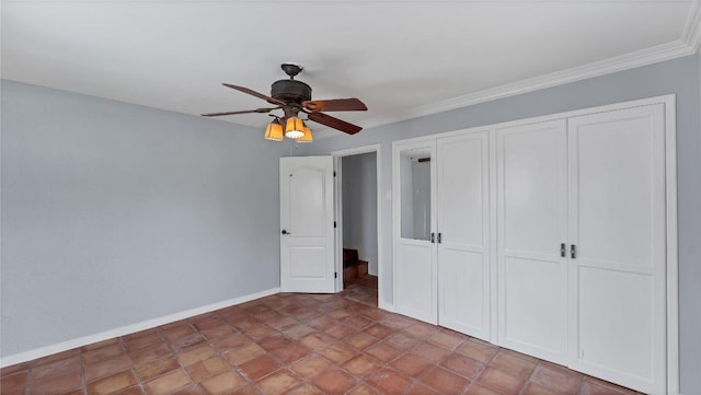unfurnished bedroom featuring a closet, baseboards, ceiling fan, and ornamental molding