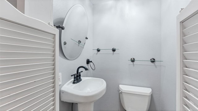 half bath featuring a sink and toilet