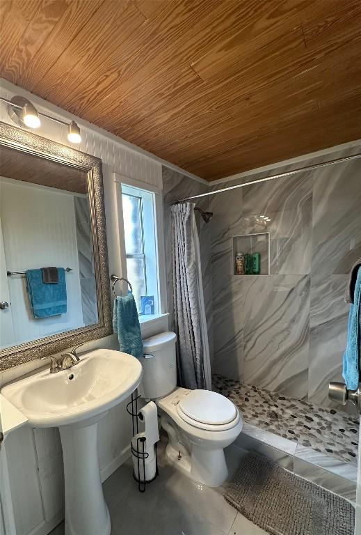 bathroom featuring toilet, wooden ceiling, and curtained shower