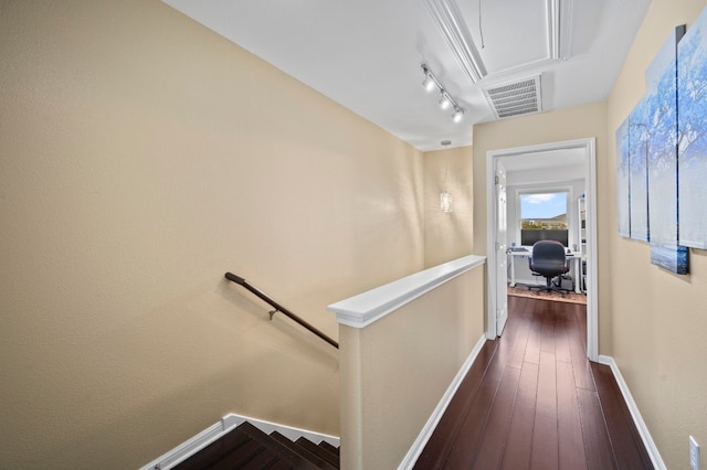 corridor featuring dark hardwood / wood-style floors and rail lighting