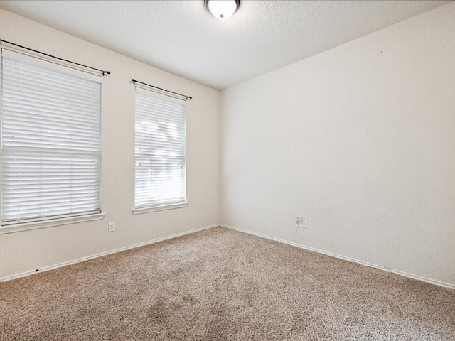 unfurnished room featuring carpet and a textured ceiling