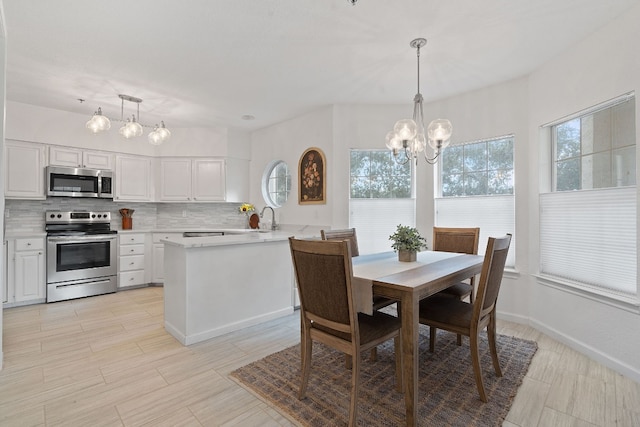 dining space featuring plenty of natural light, a chandelier, and sink