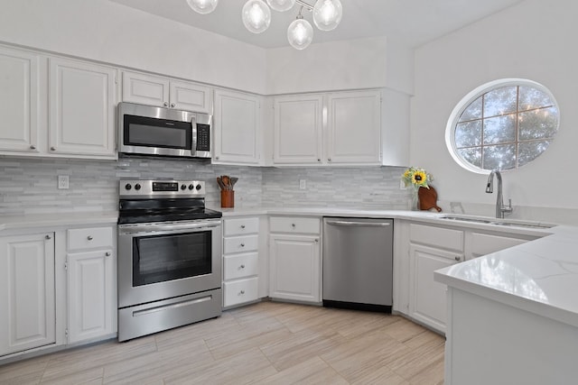 kitchen featuring tasteful backsplash, stainless steel appliances, sink, and white cabinets