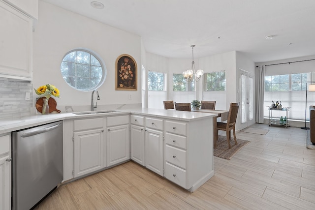 kitchen featuring dishwasher, sink, white cabinets, and kitchen peninsula