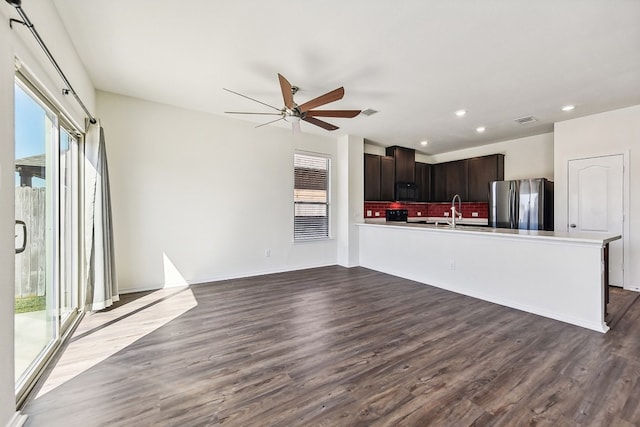 kitchen with backsplash, black appliances, dark brown cabinetry, and dark hardwood / wood-style floors