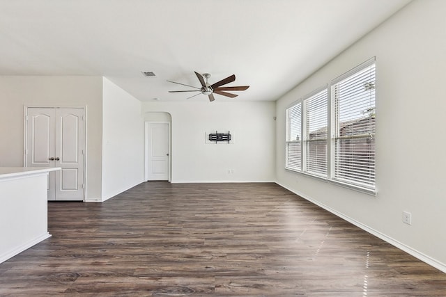 unfurnished room with ceiling fan and dark hardwood / wood-style flooring