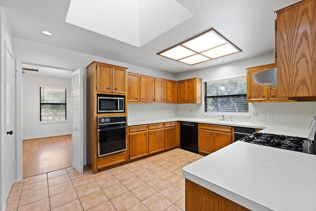 kitchen featuring sink, black appliances, light tile patterned flooring, and extractor fan