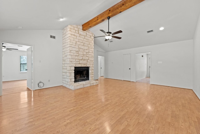 unfurnished living room with a stone fireplace, lofted ceiling with beams, light wood-type flooring, and ceiling fan