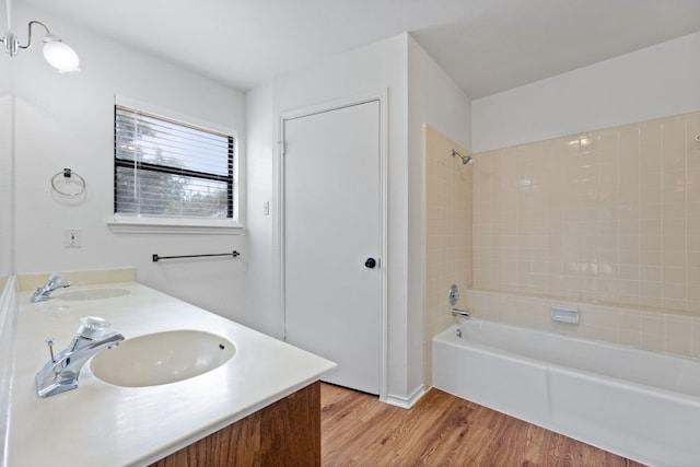 bathroom with vanity, tiled shower / bath combo, and wood-type flooring