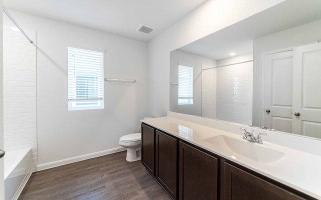 full bathroom featuring vanity, toilet, wood-type flooring, and plenty of natural light