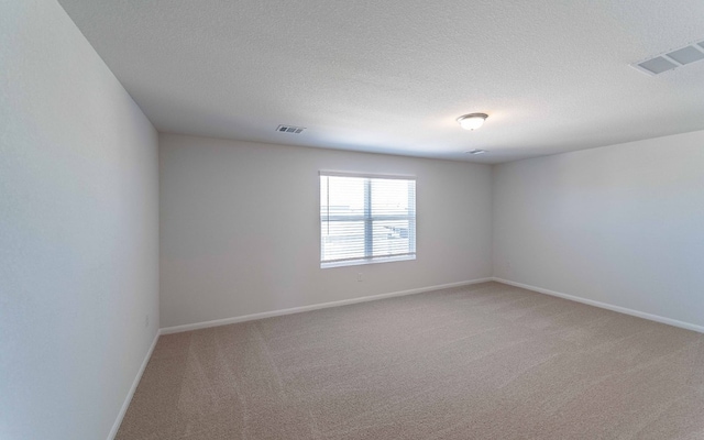 empty room with carpet flooring and a textured ceiling