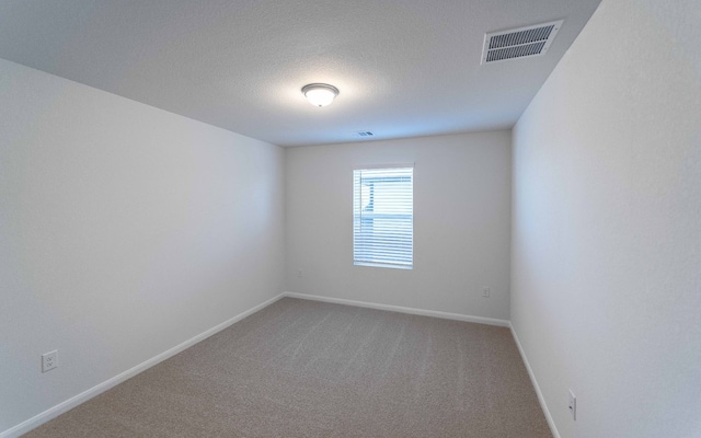 carpeted spare room featuring a textured ceiling