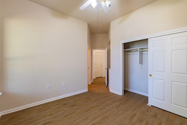 unfurnished bedroom with hardwood / wood-style floors, a closet, and ceiling fan