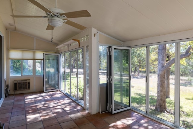 unfurnished sunroom with ceiling fan, vaulted ceiling, plenty of natural light, and a wall unit AC