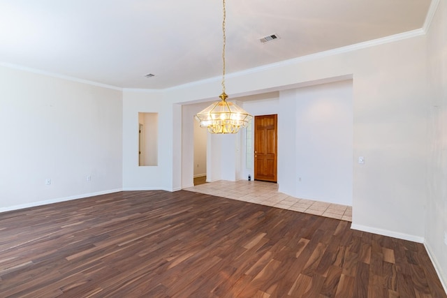 unfurnished room with ornamental molding, an inviting chandelier, and hardwood / wood-style floors