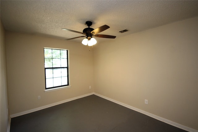 unfurnished room featuring visible vents, a textured ceiling, finished concrete flooring, baseboards, and ceiling fan