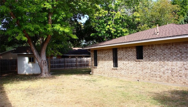 view of yard with an outbuilding, a shed, and a fenced backyard