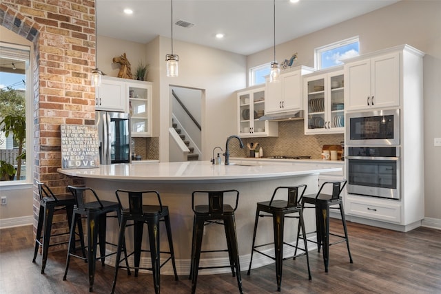 kitchen with a wealth of natural light, sink, appliances with stainless steel finishes, and hanging light fixtures