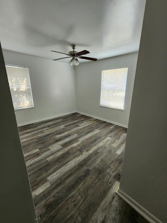 spare room featuring plenty of natural light, dark hardwood / wood-style floors, and ceiling fan