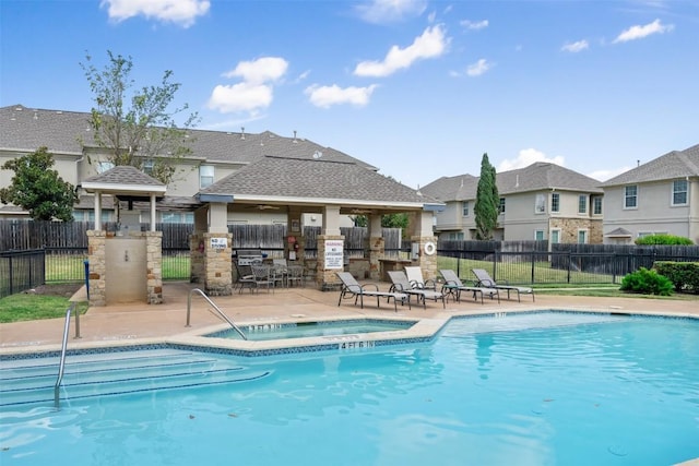 view of swimming pool featuring a hot tub and a patio area