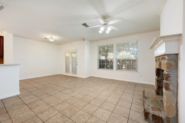 unfurnished living room with light tile patterned floors, a stone fireplace, ornamental molding, and ceiling fan