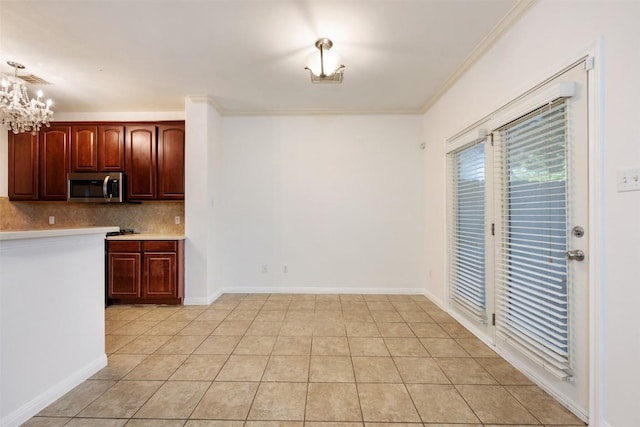 kitchen featuring hanging light fixtures, decorative backsplash, a notable chandelier, and light tile patterned flooring