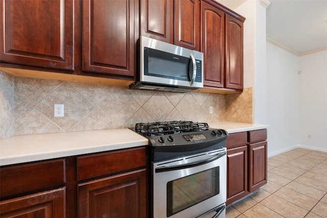 kitchen featuring tasteful backsplash, ornamental molding, appliances with stainless steel finishes, and light tile patterned flooring