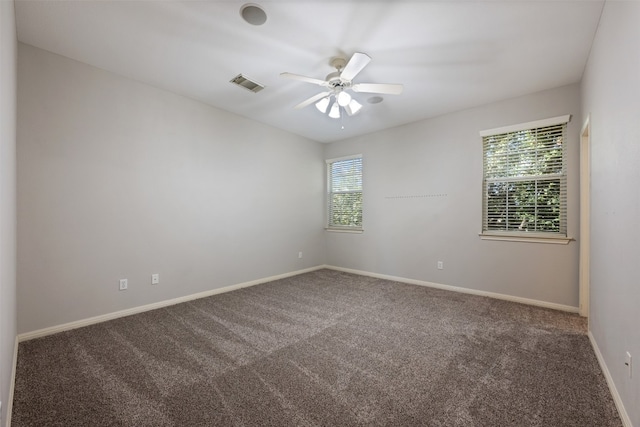 carpeted spare room featuring ceiling fan