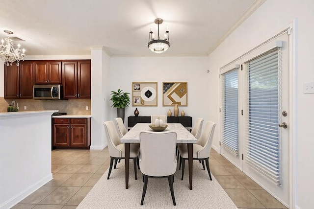 dining room featuring light tile patterned floors, ornamental molding, and a chandelier