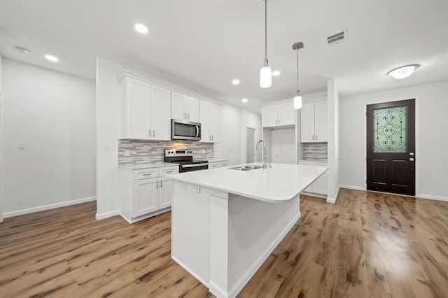 kitchen with white cabinetry, light hardwood / wood-style floors, and stainless steel appliances