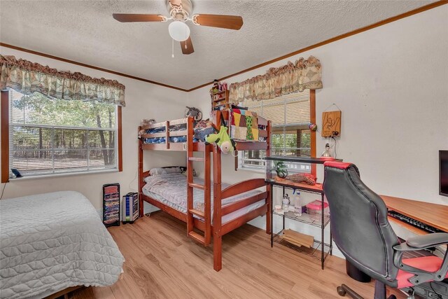 bedroom featuring crown molding, a textured ceiling, and wood finished floors